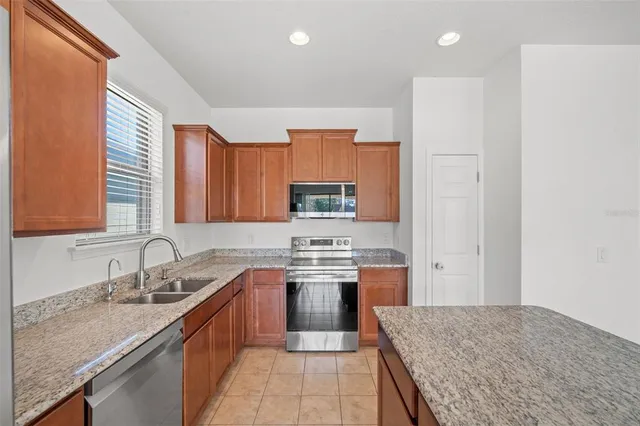 a kitchen with stainless steel appliances granite countertop a stove sink and cabinets