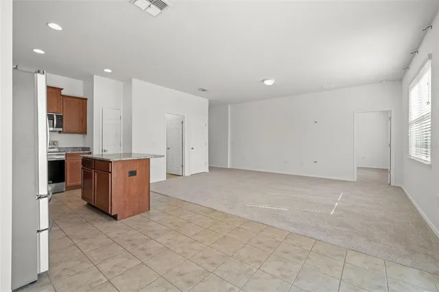 a view of kitchen with stainless steel appliances granite countertop cabinets and window
