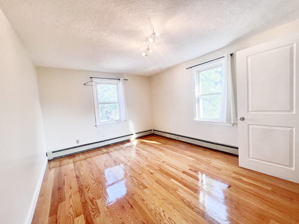 68 Maple Street Melrose, MA 02176 - Photo 33 of 39 an empty room with wooden floor and windows