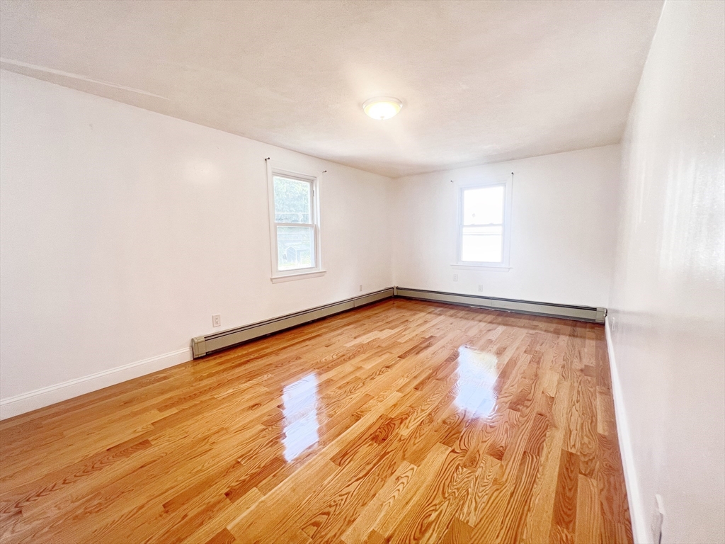 68 Maple Street Melrose, MA 02176 - Photo 35 of 39 an empty room with wooden floor and windows