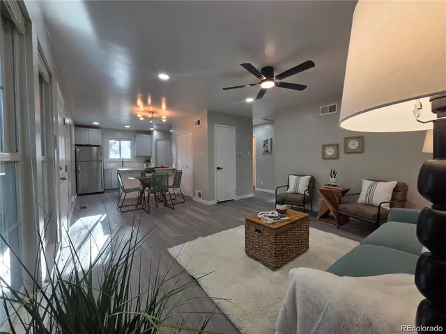 a living room with furniture and a view of kitchen