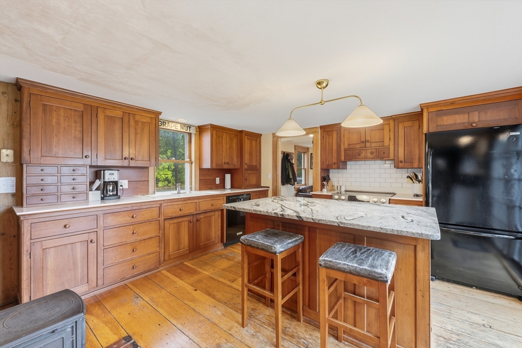 21 Rocky Hill Road Andover, MA 01810 - Photo 6 of 35 a kitchen with kitchen island granite countertop wooden cabinets and a refrigerator
