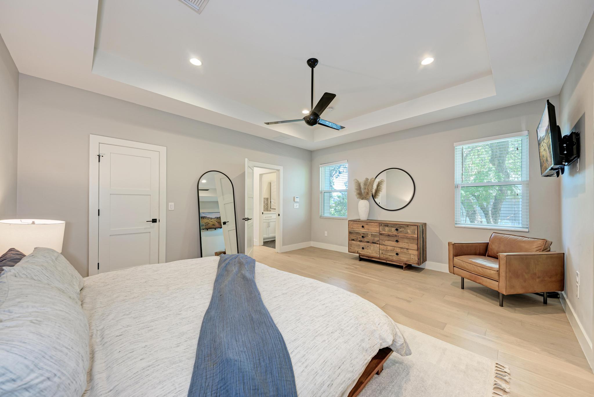918 Cardinal Lane, Unit A Austin, TX 78704 - Photo 19 of 40 Upstairs, the primary suite creates its own quiet escape with tray ceilings, warm wood floors, and generous walk-in closet.