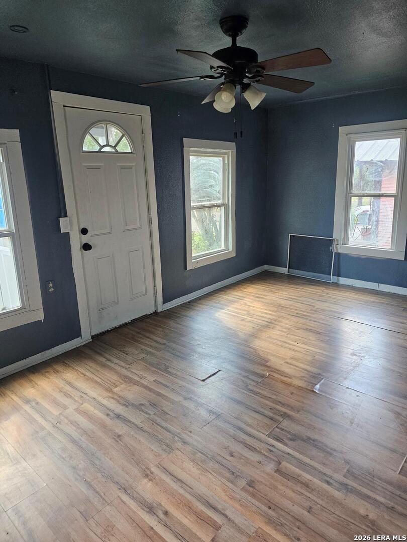 701 Roosevelt Street Longview, TX 75601 - Photo 7 of 8 an empty room with wooden floor chandelier fan and windows