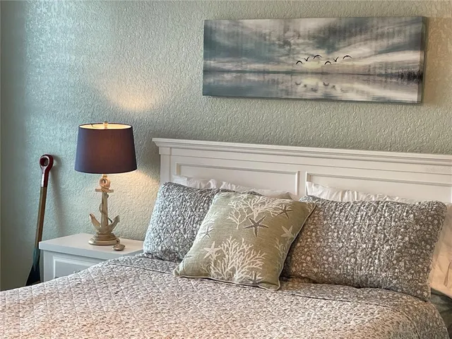 a bedroom with a bed a chandelier and a window