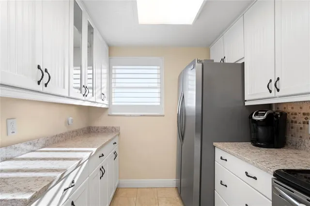a kitchen with granite countertop a sink a stove and cabinets