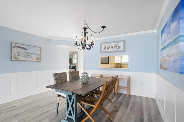 a view of a dining room with furniture a chandelier and wooden floor