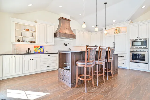 a kitchen with kitchen island a sink appliances wooden floor and a window