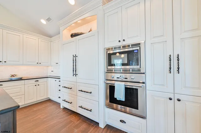 a view of a hallway with wooden floor and a chandelier