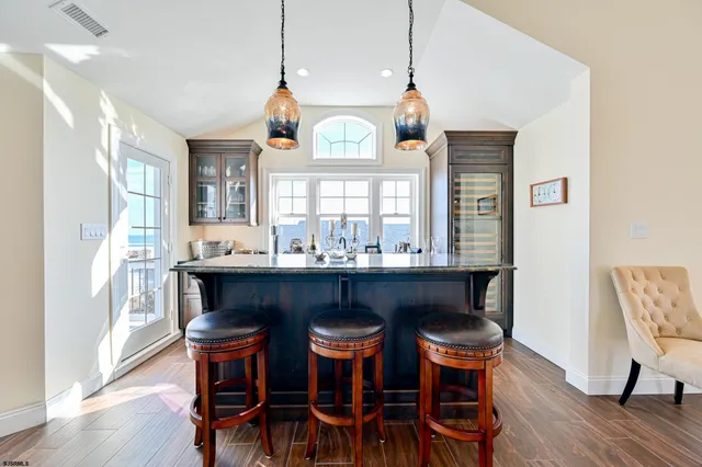 a kitchen with granite countertop a table chairs a sink dishwasher a dining table and chairs