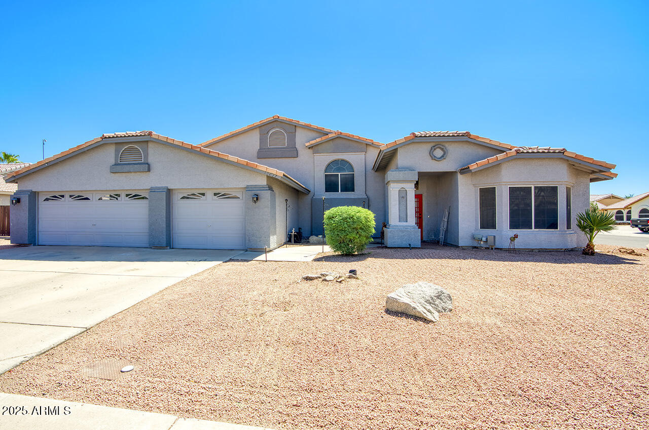 12677 North 77th Drive Peoria, AZ 85381 - Photo 1 of 25 a front view of a house with a yard and garage