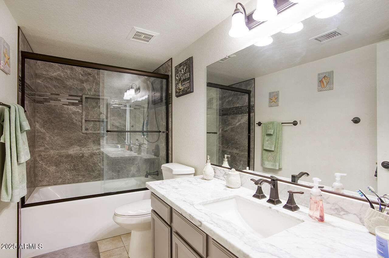 12677 North 77th Drive Peoria, AZ 85381 - Photo 12 of 25 a bathroom with a sink toilet a mirror and shower