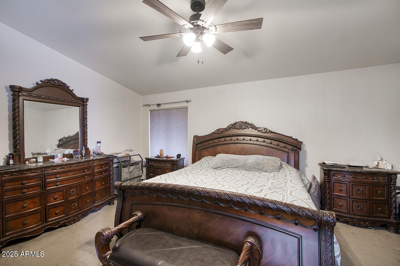 12677 North 77th Drive Peoria, AZ 85381 - Photo 14 of 25 a bedroom with a bed and dresser with mirror