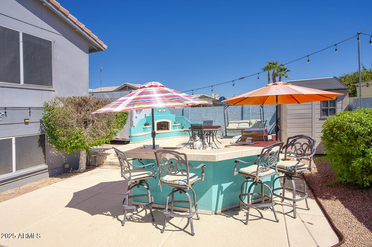 12677 North 77th Drive Peoria, AZ 85381 - Photo 20 of 25 a view of patio with chairs and tables with umbrella