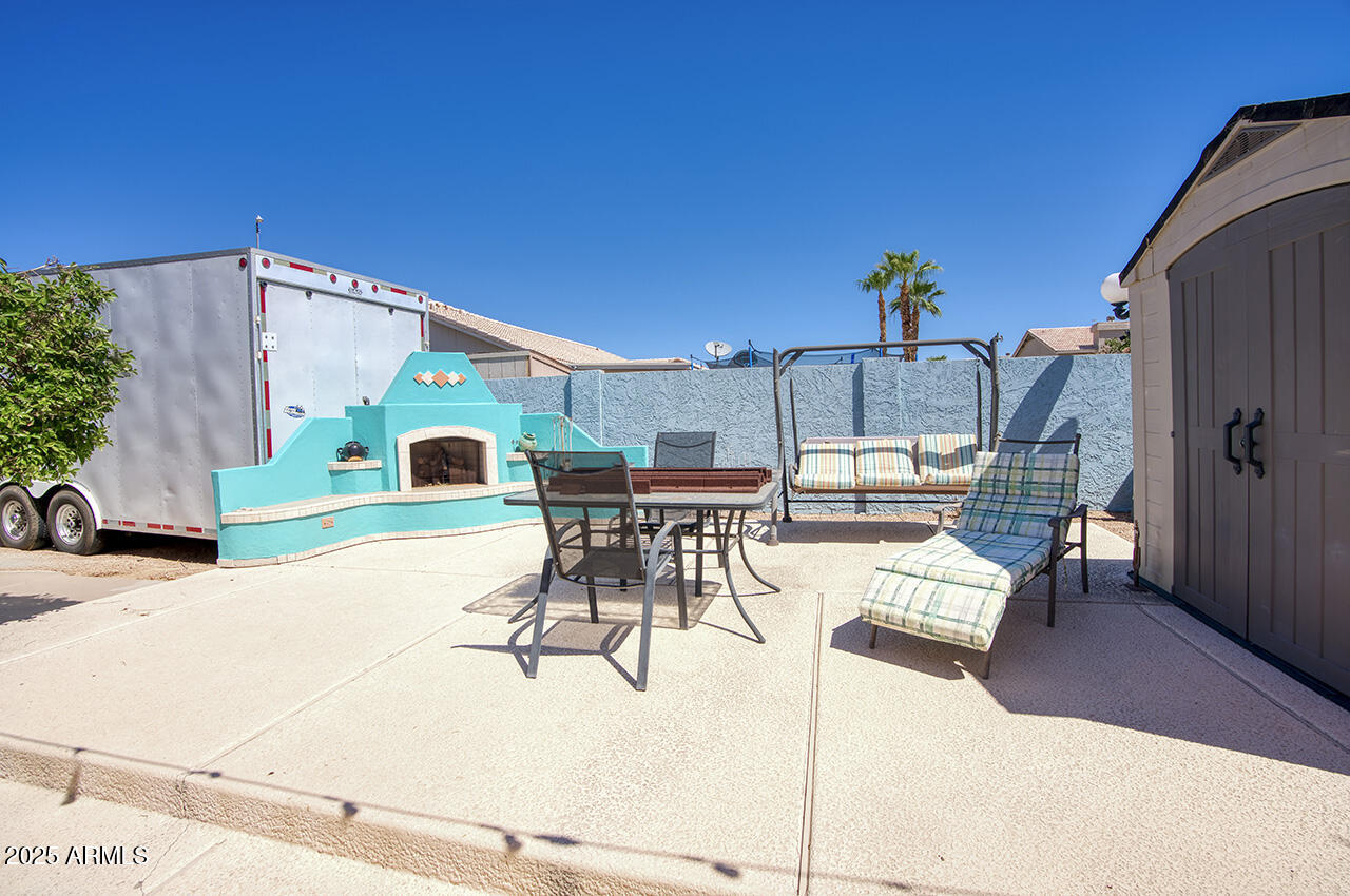 12677 North 77th Drive Peoria, AZ 85381 - Photo 21 of 25 a view of a patio with a table and chairs and potted plants