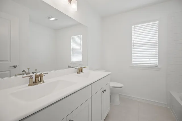 a bathroom with a sink toilet and window