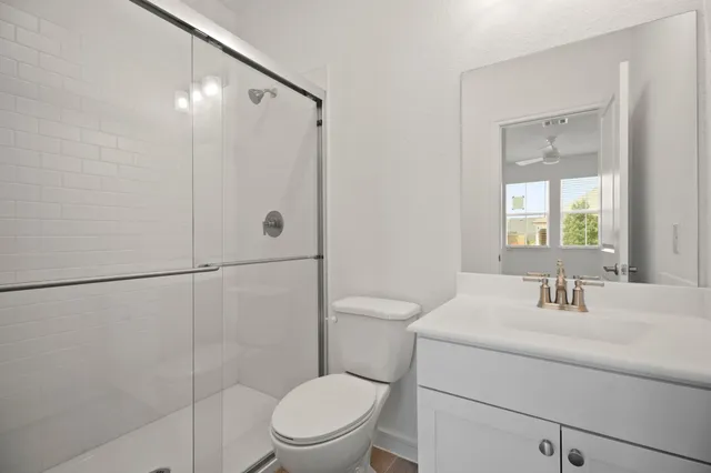 a view of a room with wooden floor a ceiling fan