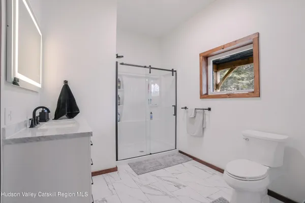 a bathroom with a sink vanity and shower