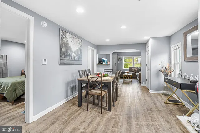 a dining room with wooden floor and large windows