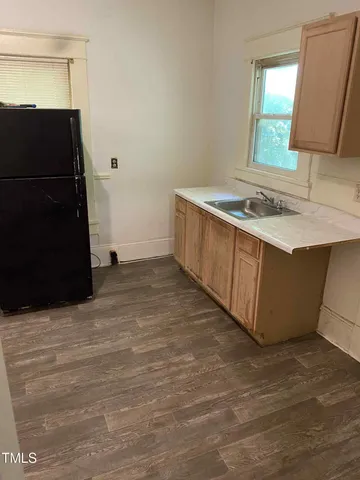 a view of a kitchen with a sink and a refrigerator