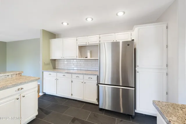 a kitchen with appliances a refrigerator a sink and cabinets