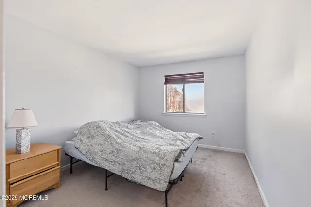 a bedroom with a bed and a lamp on desk
