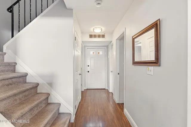 a view of a hallway with wooden floor and entryway