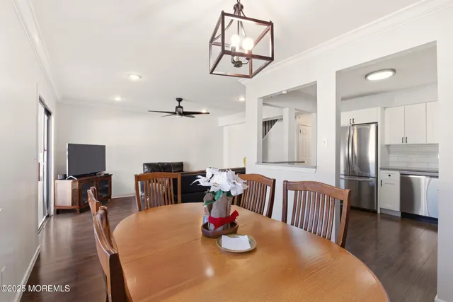 a dining room with stainless steel appliances a table and chairs