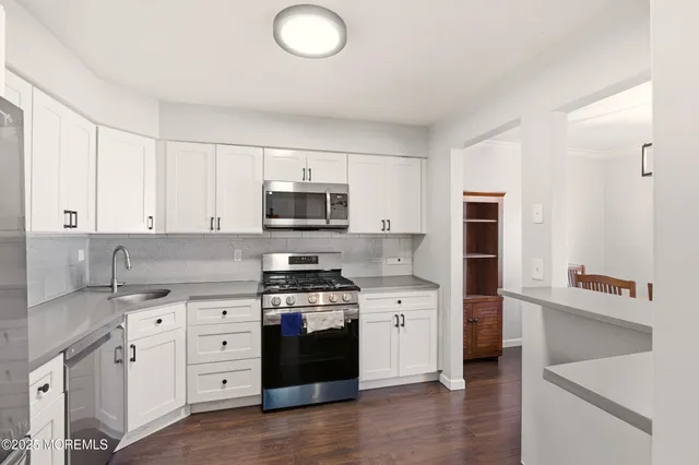 a kitchen with stainless steel appliances a sink stove and cabinets