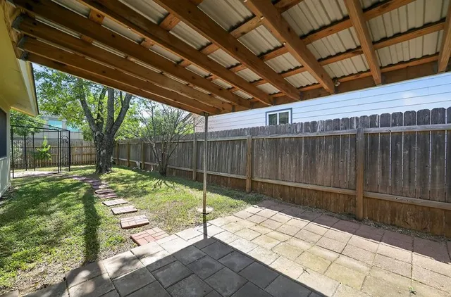 a view of backyard with wooden fence