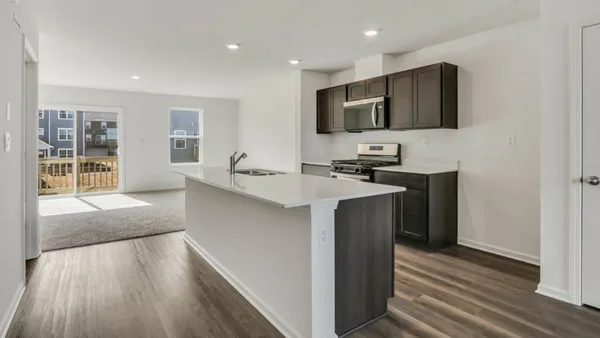 a kitchen with stainless steel appliances a stove a sink a microwave a refrigerator and cabinets