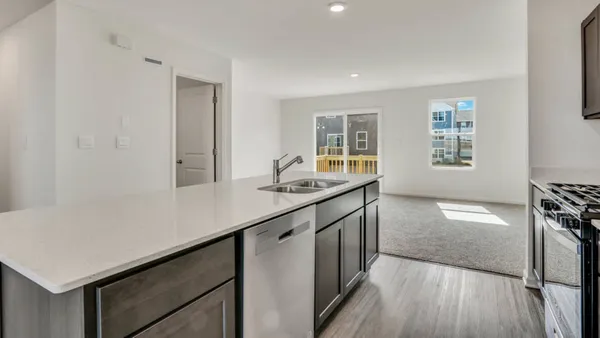 a kitchen with granite countertop a sink appliances cabinets and wooden floor