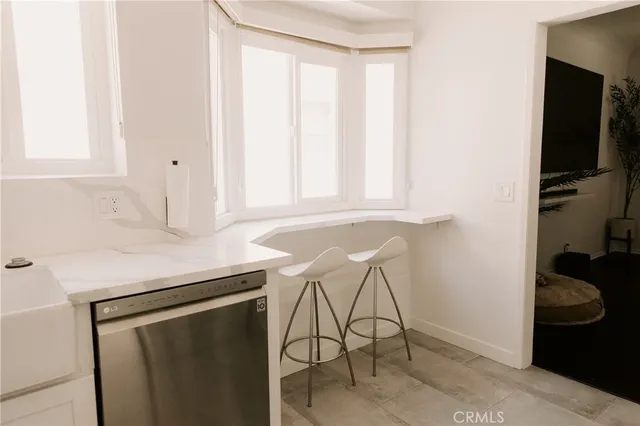 a room with a table chairs and a window