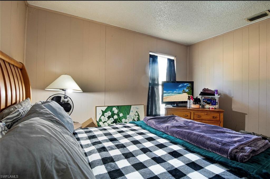 318 Bellair Road Fort Myers, FL 33905 - Photo 11 of 29 a bedroom with a bed and a mirror on dresser