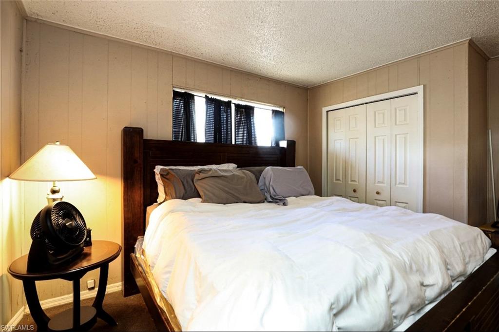 318 Bellair Road Fort Myers, FL 33905 - Photo 13 of 29 a bed sitting in a bedroom next to a window with lamp