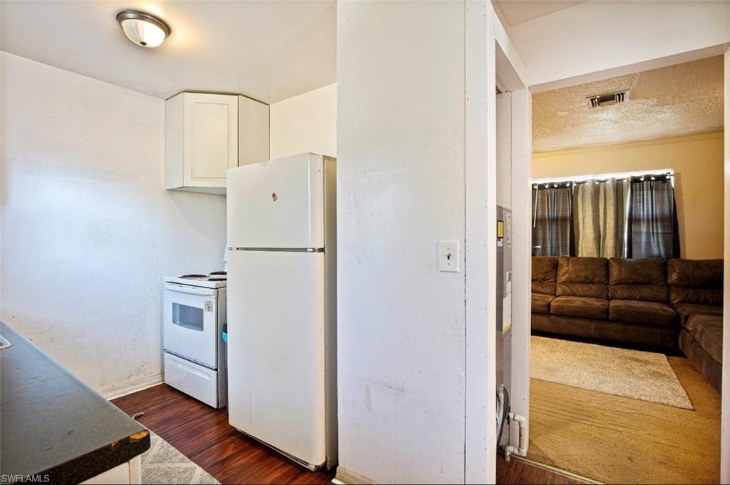 318 Bellair Road Fort Myers, FL 33905 - Photo 9 of 29 a kitchen with a refrigerator and cabinets