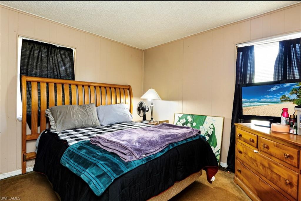 318 Bellair Road Fort Myers, FL 33905 - Photo 10 of 29 a bedroom with a bed and a flat tv screen on dresser