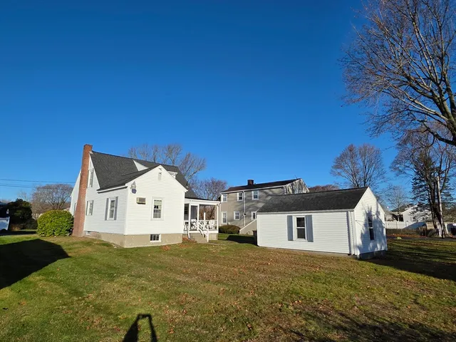 a view of a white house with a yard