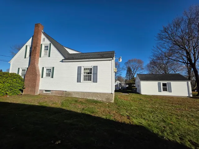 a view of a house with backyard and trees