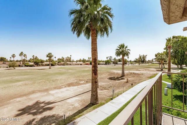 a view of a swimming pool with an outdoor seating and house in the background