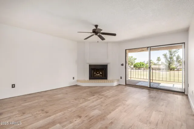 a view of an empty room with a window and a fireplace