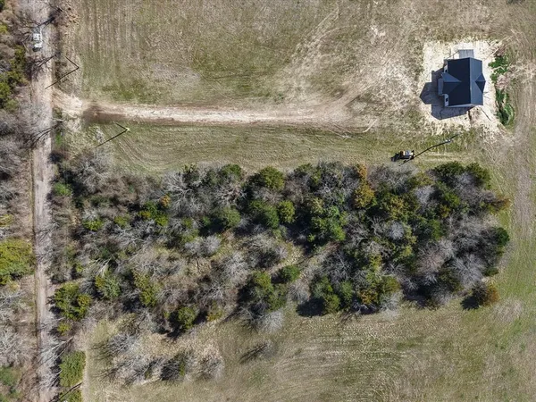 a view of a dry yard with wooden fence