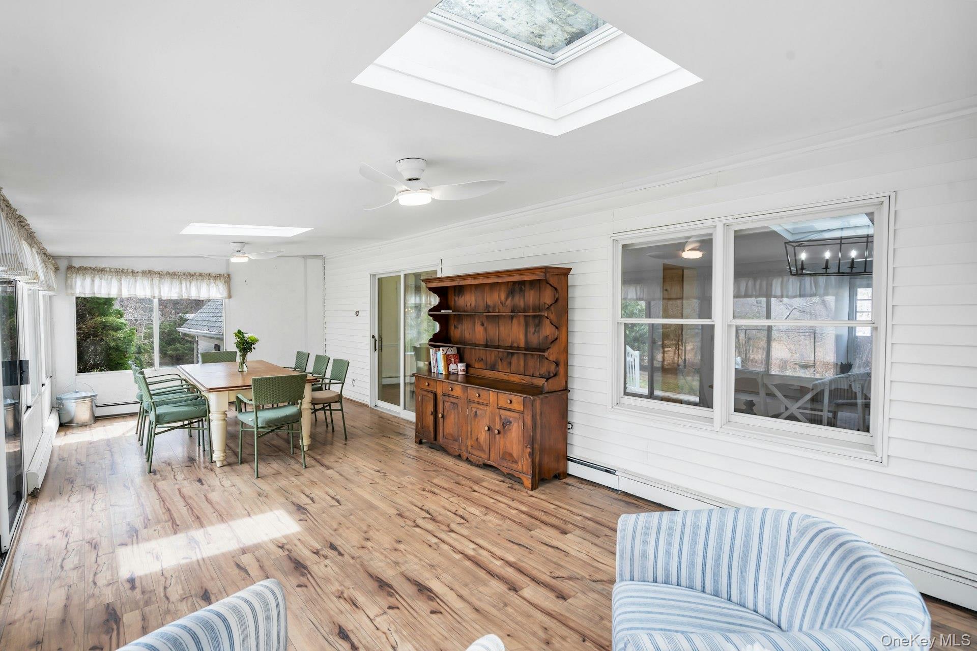 5845 North Bayview Road Southold, NY 11971 - Photo 10 of 24 3 season sunroom featuring a large table, panoramic windows and sunlights