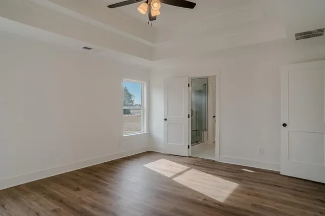 a view of an empty room with wooden floor