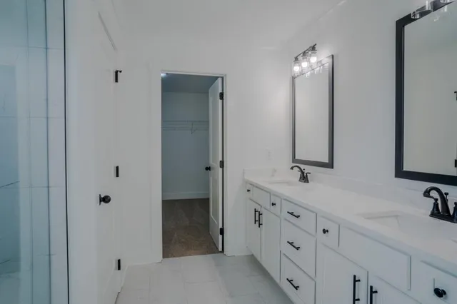 a bathroom with double vanity sinks and a mirror