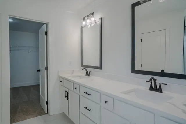 a bathroom with double sink and a mirror