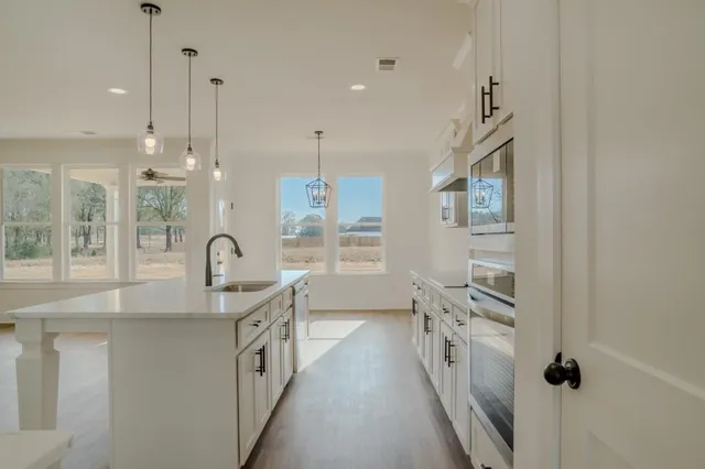 a kitchen with white cabinets and sink