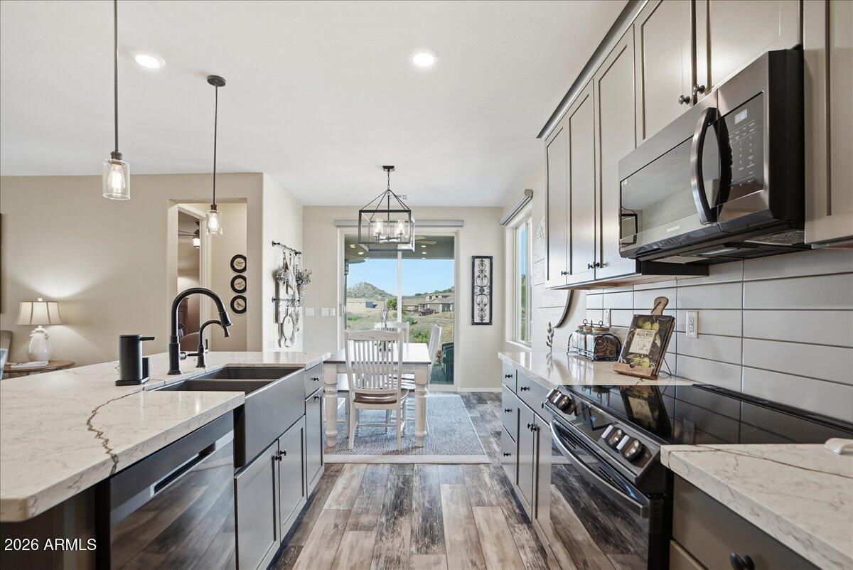 6150 North Stratford Court Rimrock, AZ 86335 - Photo 20 of 60 a kitchen with stainless steel appliances granite countertop a sink a stove and a wooden floors
