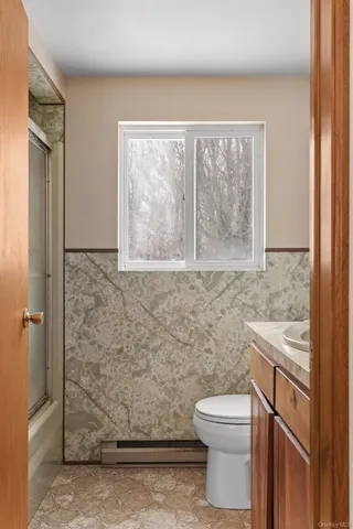a bathroom with a granite countertop toilet a sink and a shower