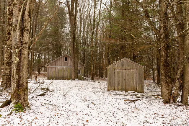 a wooden house with trees in the background